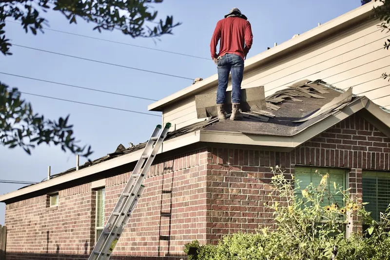 Professional roofer working on a residential roof in Rolling Acres